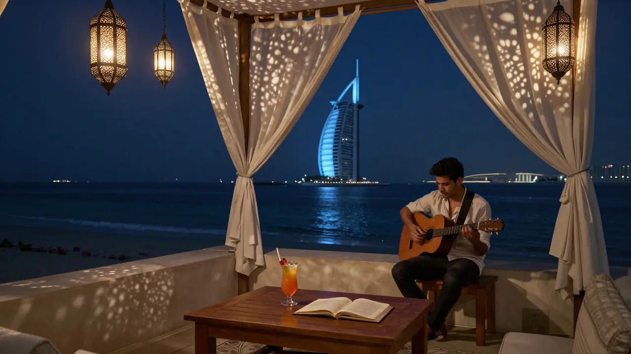 A serene rooftop at night with lanterns, white linens, and a view of the Dubai skyline over the sea.
